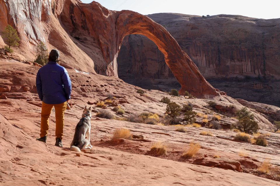 Standing with Ghost, my husky, looking up at Corona Arch near Moab, Utah